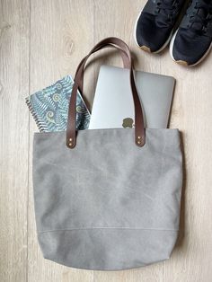 "Gray canvas tote with brown leather straps This tote bag is a perfect size to carry all your essentials for the day. It is cute and stylish and will last for years and years. It is made with beautiful and durable stone washed canvas in light gray. The straps are brown leather. The lining has two slip pockets and a magnet snap to hold closed. It measures 16.5\" wide at the top 12.5\" wide at the bottom 13\" tall 4.5\" deep Please let me know if you have any questions" Slouchy Purse, Grey Tote Bags, Wedding Bags, Grey Tote, Hobo Purse, Wedding Bag, Brown Leather Strap, Bag Canvas, Accessories Bags Purses