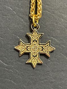 After years of searching for something like this, I decided to make them myself. This double-sided Coptic Orthodox Cross pendant is a stunning addition to any collection. The cross is gold plated and measures 1" across, and has an optional chain to accompany it. The intricate design of the cross is a beautiful representation of the Coptic Orthodox faith. Made in Canada, this pendant is die cast and then gold plated and is perfect for any collector of unique jewelry. It is a great way to show you Gold Metal Cross Jewelry, Symbolic Cross Jewelry For Jewelry Making, Gold Engraved Pendant Chain Necklace, Gold Cross Necklaces For Jewelry Making, Gold Pendant Chain Necklace, Gold Cross Chain Necklace With Adjustable Chain, Gold Spiritual Cross Necklace Tarnish Resistant, Collectible Gold Pendant Necklace, Spiritual Gold Cross Necklace Tarnish Resistant