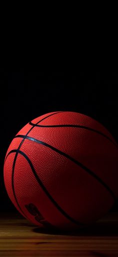 a red basketball sitting on top of a wooden floor