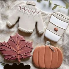 some cookies are sitting on a table with leaves and other decorations around them, including a maple leaf