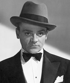 a man in a tuxedo and bow tie is looking at the camera while wearing a hat