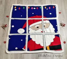 a crocheted christmas blanket with santa clause on it