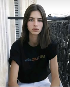 a young woman sitting on top of a wooden bench next to a window sill