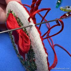 someone is working on something with yarn and needles in the process of making a christmas wreath ornament