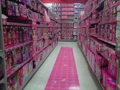 there is a pink carpet in the middle of this aisle that has barbie dolls on it