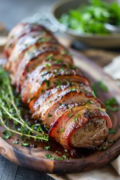 meat wrapped in bacon and garnished with parsley on a wooden platter