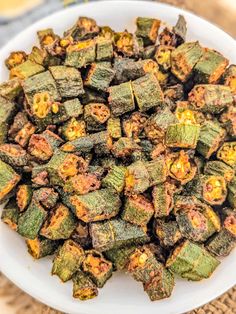 a white bowl filled with fried vegetables on top of a table