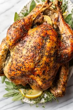 a roasted chicken with herbs and lemons on a plate