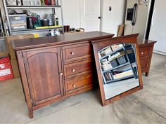 a wooden desk with a mirror on it in a room filled with boxes and other items