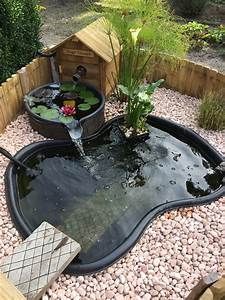 a small pond in the middle of a graveled area with water flowing from it