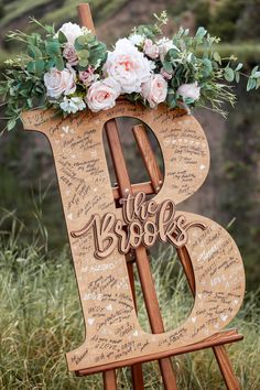 a wooden easel with flowers and writing on it