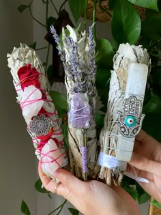 three different types of dried flowers are being held by someone's hands and holding them together