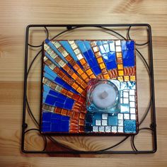 a candle holder made out of colorful glass tiles