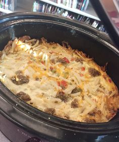 a crock pot filled with cheese and meat