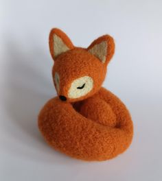 an orange stuffed animal sitting on top of a white table