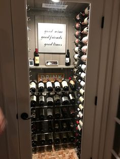 a wine cellar with many bottles of wine on the shelves and behind it is an open door