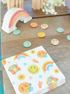 a table topped with lots of colorful buttons and stickers next to a rainbow shaped object