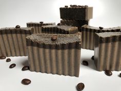 five pieces of chocolate sitting on top of coffee beans next to each other and one piece has been cut in half