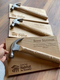 three wooden business cards with hammers and wrenches on them, one being held by a person