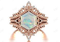 an opalite and diamond ring in rose gold with diamonds on the sides, surrounded by filigrees