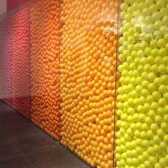 there are many different colored balls on the wall in this room and one is yellow