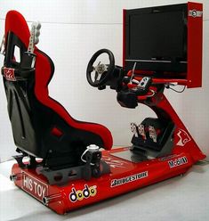 a red racing car with a tv and steering wheel in the center, sitting on a white surface