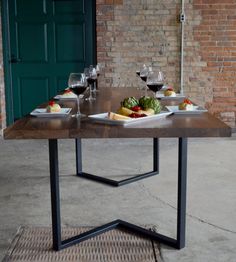 a table that has some food on it and glasses of wine in front of it