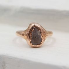 This dainty ring features one roughly 10mm pale purple beach pebble, perfect for anyone looking for a naturally lovely everyday ring. The band is made of 12-gauge, half-round copper, and this ring is a size 5. This ring is currently not available for custom orders. Sorry! This ring has been made through the electroforming process. That means no two rings are alike!  Want to make it a stack? Check out our plain and pointed stacking copper bands to add on to this ring!  https://www.etsy.com/listing/676000876/copper-stacking-bands-minimalist-ring ---A special note about copper jewelry-- Over time, copper naturally loses its finish and can cause your finger to turn green when it is in contact with sweat or oils. Have no fear! Simply keep your copper clean and dry as much as possible, maybe occ Minimalist Jewelry With Natural Inclusions For Everyday, Minimalist Everyday Jewelry With Natural Inclusions, Minimalist Adjustable Rings With Raw Stone, Rose Gold Hand Forged Promise Ring, Earthy Gemstone Rings For Gifts, Earthy Gemstone Rings For Gift, Earthy Gemstone Rings As Gifts, Rustic Hand Forged Ring Jewelry, Minimalist Rings With Raw Stone For Gift