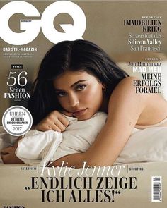 a woman laying on top of a bed next to a magazine cover with the word gq