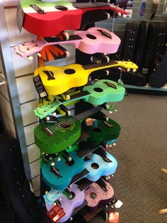 guitars are stacked on top of each other in a room with carpeted flooring