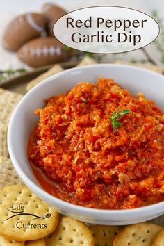 red pepper garlic dip in a white bowl with crackers