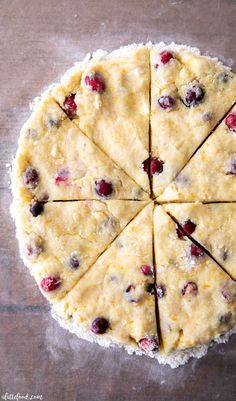 an uncooked pie with cranberries and white bread crust on a wooden table