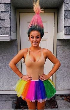 a woman wearing a rainbow colored skirt and tank top with her hands on her hips