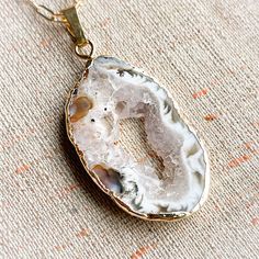 These freeform agate druzy pendants are each beautifully organic and unique. Druzies form from the Agate as tiny, glittering crystals sparkling in the light like sugar or snow. Druzy is created when water deposits crystals onto a rock’s surface. When the water evaporates and cooling occurs, the minerals are left behind and form into crystals on the rock.Choose a gold or silver toned setting and embrace the centering power of Agate in your life! White Agate Round Pendant Jewelry, White Nature-inspired Necklaces For Healing, Nature-inspired White Necklaces For Healing, Teardrop Agate Jewelry For Healing, Spiritual Agate Teardrop Pendant Jewelry, Large Agate Geode For Spiritual Purposes, Large Agate Geode For Spiritual Use, Agate Jewelry With Large Stone For Gifts, Healing Teardrop Agate Jewelry