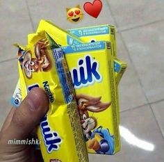 a person holding up two packets of milk with emoticions on them and hearts floating around