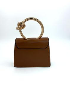 Gold circular handle structured handbag with detachable crossbody chain. Brown Satchel With Round Handle And Gold-tone Hardware, Brown Satchel With Gold-tone Hardware And Round Handle, Top Handle Satchel With Handles As Fashion Accessory, Daily Shoulder Bag With Metal Hardware And Round Handle, Daily Use Shoulder Bag With Metal Hardware, Chic Satchel With Round Handle And Metal Hardware, Trendy Evening Bag With Gold-tone Hardware And Top Handle, Gold Shoulder Bag With Metal Hardware And Round Handle, Gold Shoulder Bag With Round Handle And Metal Hardware