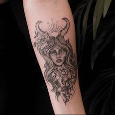 a woman with horns and flowers on her arm