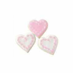 three pink and white heart shaped cookies sitting on top of each other in front of a white background