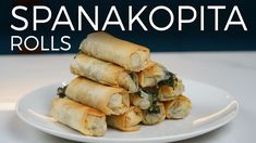 a stack of spinach rolls on a plate with the words spanakopita rolls