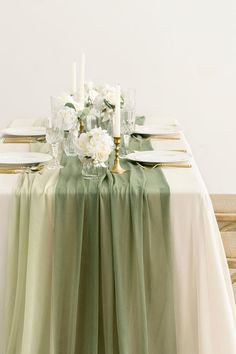 the table is set with white flowers and candles