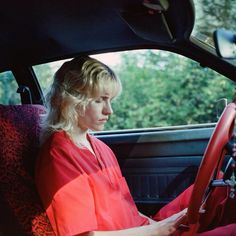 a woman sitting in the driver's seat of a car