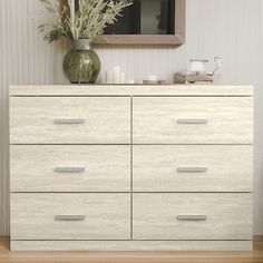 a white dresser sitting in front of a mirror