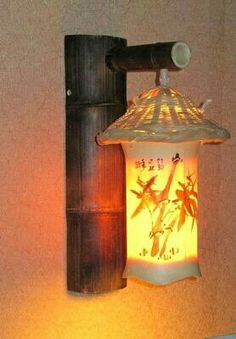 a light that is on the wall next to a lamp fixture with bamboo leaves painted on it