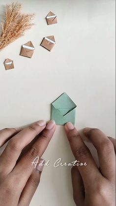 two hands are making origami shapes out of paper