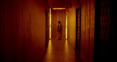 a man is standing in the hallway with his back turned to the camera and lights on