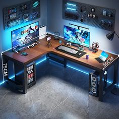 a computer desk with two monitors on top of it and some game controllers in the background