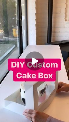 a woman is opening up a cake box