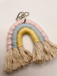 a keychain with two tassels hanging from it's side on a white surface