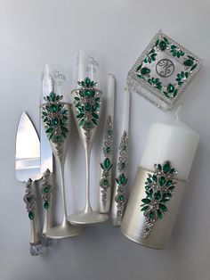 a set of silverware with green flowers on them and a cake server in the middle