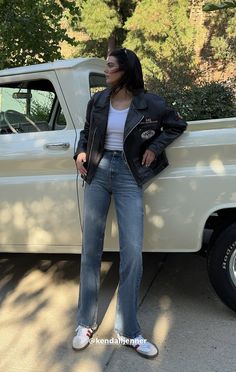 a woman standing next to a white truck